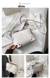White shoulder bag with silver rivet details and zipper closure in three-panel layout