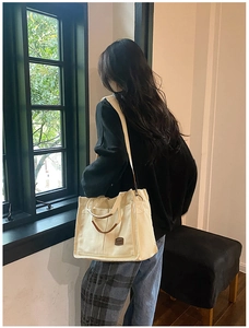 Off-white canvas tote bag with leather handles shown in a bright window lifestyle setting