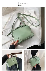 Close-up of green square crossbody bag with silver studs and adjustable shoulder strap