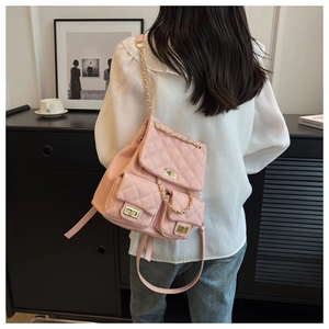 Detail of pink quilted backpack for women featuring gold chain straps and metal twist lock
