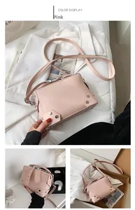 Pink crossbody square bag with silver stud accents and adjustable shoulder strap detail