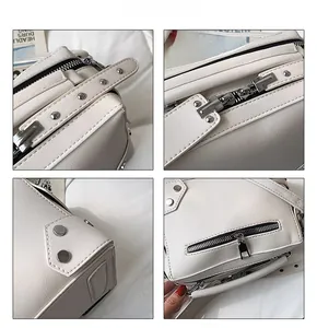 Detail view of white lychee grain leather crossbody bag featuring silver metal rivets and zippers