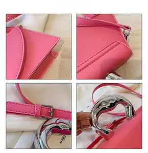 Detail showing fuchsia leather bag with irregular silver metal handle and fine stitching