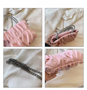 Detail of pink ruched cloud bag featuring a sparkling rhinestone handle and chain strap