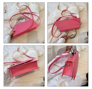 Detail view of bright pink geometric handbag with silver heart-shaped metal handle