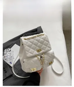 Close-up of beige quilted backpack featuring gold metal twist locks and chain straps