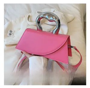 Pink asymmetrical leather handbag featuring a unique liquid silver metal handle and strap