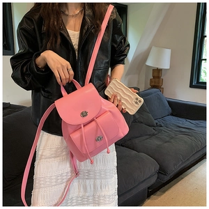 Close-up of pink mini backpack with silver twist locks and faux leather texture