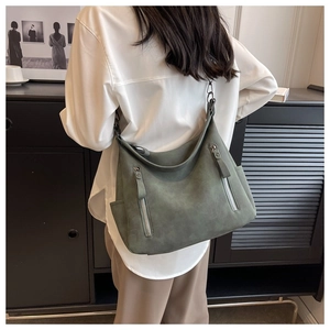 Detailed view of large dark green matte leather tote bag with dual silver vertical zippers