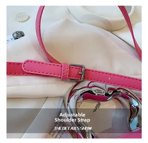 Detail of adjustable pink leather shoulder strap with silver buckle and fine stitching