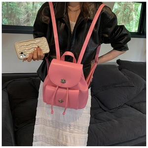 Pink PU leather mini backpack with metal twist lock and drawstring detail on model