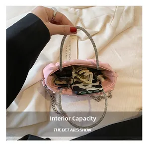 Interior capacity of the pink pleated cloud bag showing phone, sunglasses, and makeup