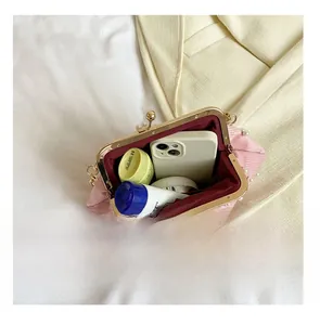 Détail montrant la capacité intérieure d'une pochette rose à perles avec accessoires