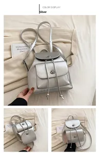 Detail view of silver backpack with metallic finish, drawstring closure, and metal lock buckle