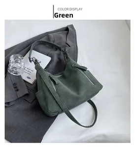 Detail view of green vintage tote bag with multiple zippers and matte suede texture
