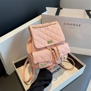 Pink quilted backpack with gold chain straps and three turn-lock closures in a gift box