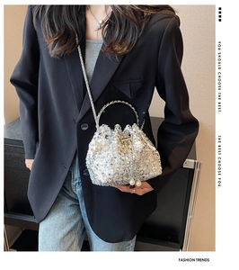Detail of silver sequin bucket bag with metal chain strap and pearl drawstring charm