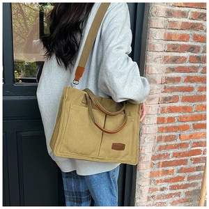 Outdoor shot of canvas tote bag in mustard yellow with double pockets and adjustable strap