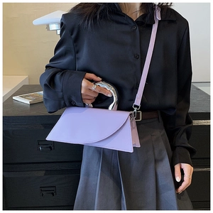 Detail of lavender geometric handbag with irregular silver metal handle shown on shoulder
