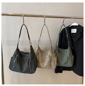 Close-up of three retro matte hobo bags in black, khaki and green with double zipper detail