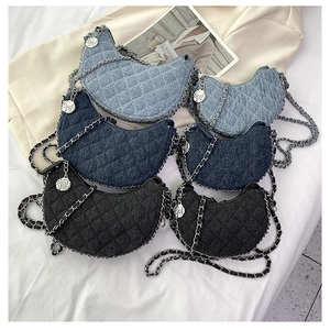 Detail of denim quilted crescent bags with metal chain straps and rose charms