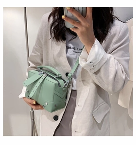 Mirror selfie showing mint green crossbody bag with silver studs and double zippers