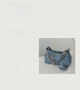 Détail du sac croissant en denim avec chaîne argentée et bandoulière réglable