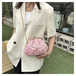 Détail du sac à main rose orné de perles avec fermoir à clip et chaîne dorée