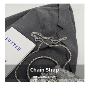 Detail of silver sequin bucket bag with round metal handle and delicate chain strap
