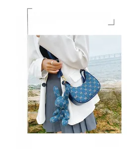 Détail du sac hobo en denim avec motif jacquard M et pendentif lapin mignon attaché