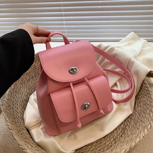 Pink faux leather backpack with silver turn-lock and drawstring closure in soft light