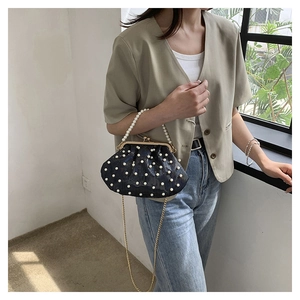 Gros plan d'un sac de soirée rétro noir orné de perles avec bandoulière dorée
