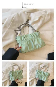 Detailed view of mint green ruched cloud bag with sparkling rhinestone handle and chain