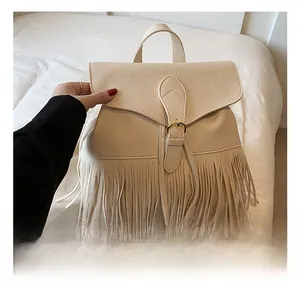 Détail du sac à dos beige à franges avec cuir grainé et boucle dorée élégante
