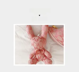 Gros plan d'un pendentif lapin rose pour sac avec motifs et chaîne dorée