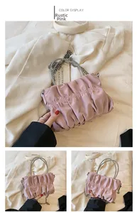 Close-up of dusty pink ruched cloud bag featuring a sparkling rhinestone handle and chain