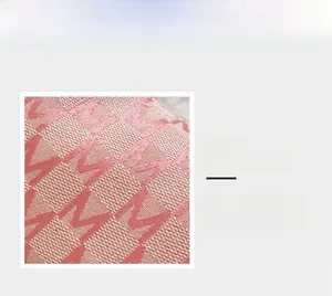 Gros plan du tissu jacquard avec motif M rose sur le sac à main en forme de croissant