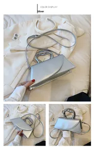 Detail view of a silver mirror-finish handbag with artistic heart-shaped metal handle