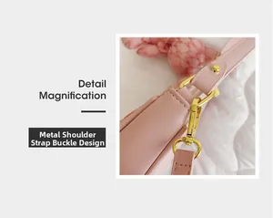 Gros plan sur la boucle en métal doré et la bandoulière en cuir du sac demi-lune rose