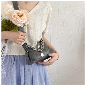 Détail du sac croissant en cuir gris vieilli avec chaîne argentée et pendentif