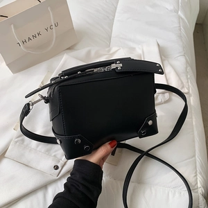 Chic black box crossbody bag with silver studs on a clean minimalist white background