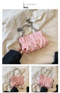 Detail of pink ruched cloud bag featuring rhinestone handle and silver chain strap