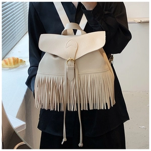 Détail du sac à dos crème avec texture cuir grainé et longues franges décoratives