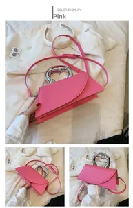 Pink designer handbag with large silver metal handle and adjustable crossbody strap