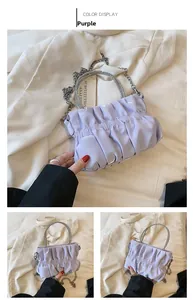 Detail of lavender pleated cloud bag with silver rhinestone handle and metal chain strap