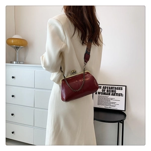 Retro burgundy leather shell bag with vintage metal clasp and embroidered strap detail