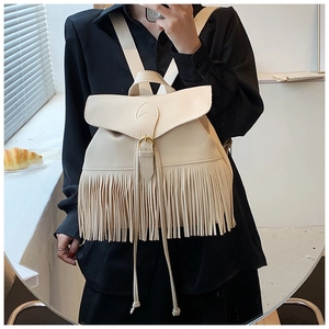 Détail du sac à dos à franges crème avec texture grainée et boucle dorée de fermeture