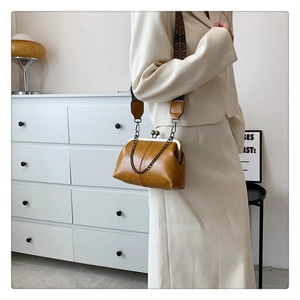 Detail of vintage caramel shell bag with antique bronze frame and ethnic woven strap
