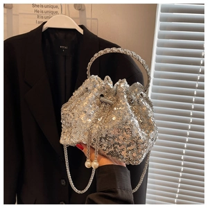 Macro shot of silver sequin bucket bag featuring pearl charms and crystal round handle