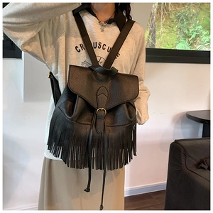 Détail du sac à dos en similicuir noir avec de longues franges et fermeture à cordon